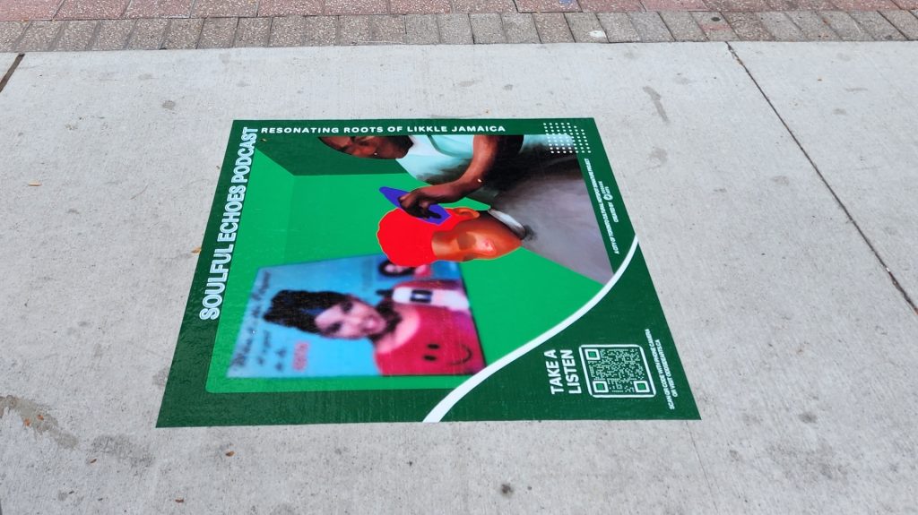 Sidewalk sticker showing a black boy getting his hair cut by a barber.